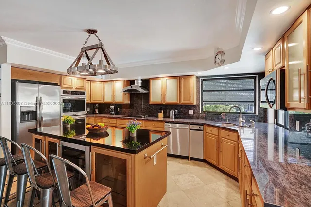 a kitchen with stainless steel appliances a stove a sink and a refrigerator
