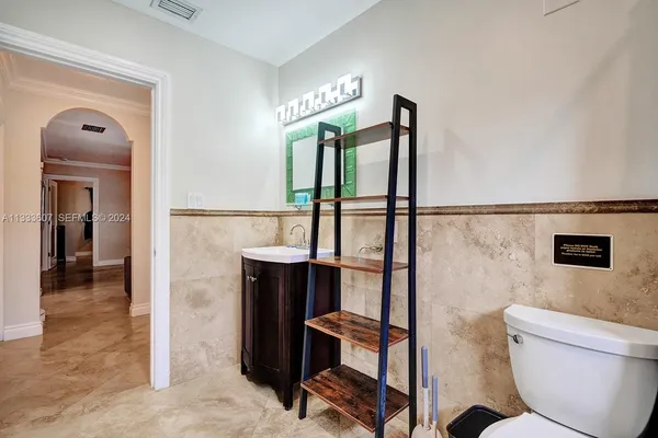 a bathroom with a toilet a sink and mirror