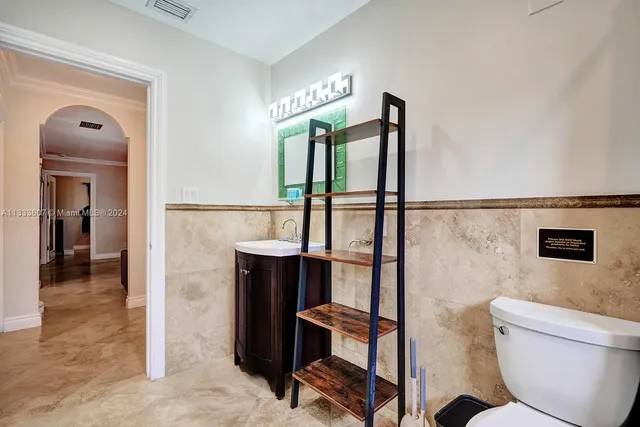 a bathroom with a toilet a sink and mirror