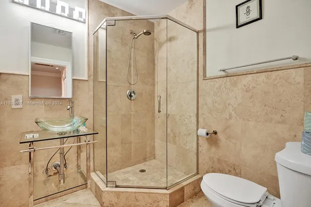a bathroom with a shower a toilet and a sink
