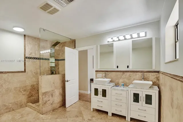a bathroom with a sink a mirror and shower