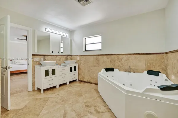 a bathroom with a bathtub sink and mirror
