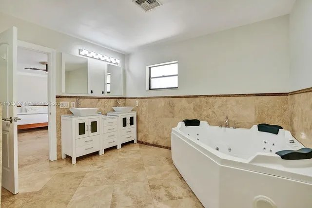 a bathroom with a bathtub sink and mirror