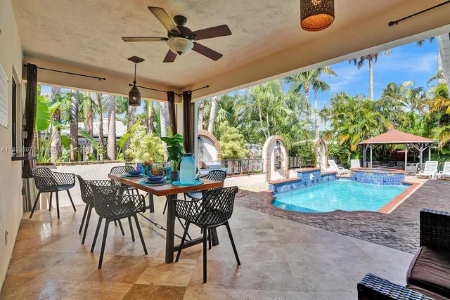 a dining room with furniture and a floor to ceiling window