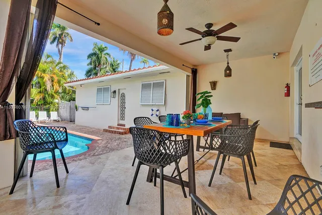 a dining room with furniture a rug and a potted plant
