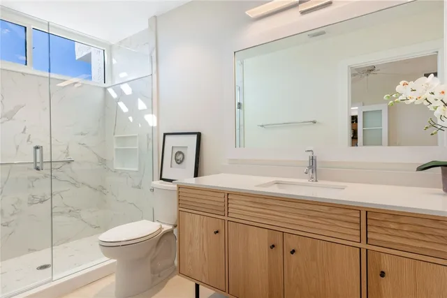 a bathroom with a sink a toilet and shower