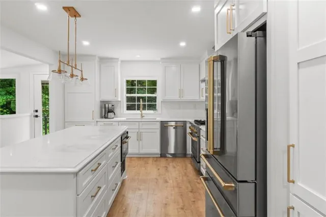 a kitchen with stainless steel appliances granite countertop a stove and white cabinets