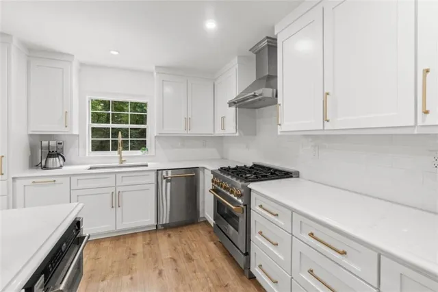 a kitchen with white cabinets and stainless steel appliances