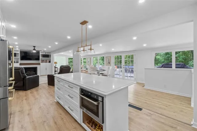 a large white kitchen with lots of counter space dining table and chairs