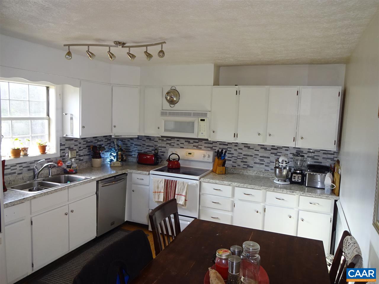 1119 Hollands Road Palmyra, VA 22963 - Photo 6 of 17 a kitchen with a sink white cabinets and black appliances