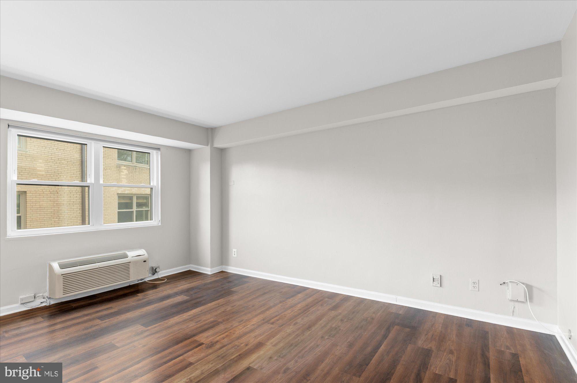 1801 Clydesdale Place Northwest, Unit 505 Washington, DC 20009 - Photo 11 of 21 an empty room with wooden floor and windows
