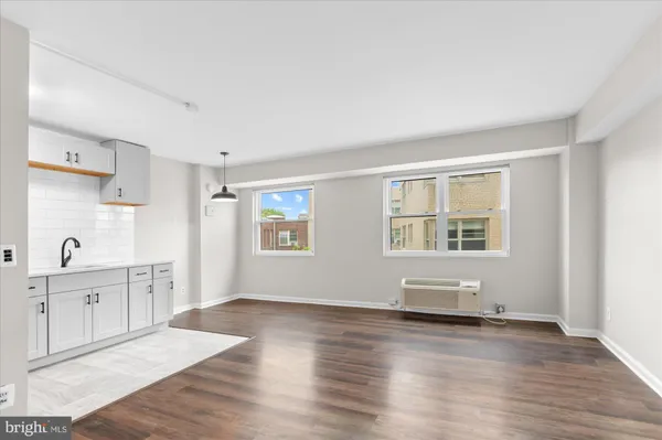 a kitchen with stainless steel appliances a sink cabinets and wooden floor