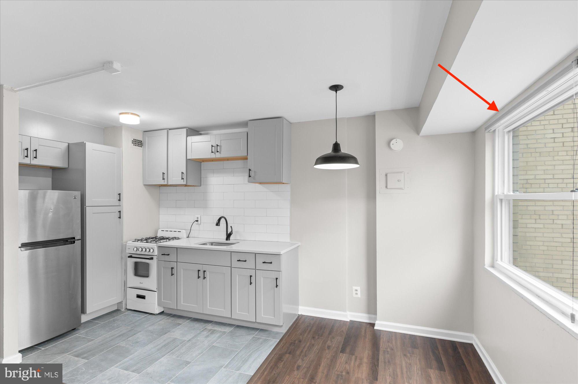 1801 Clydesdale Place Northwest, Unit 505 Washington, DC 20009 - Photo 6 of 21 a kitchen with stainless steel appliances a sink cabinets and wooden floor