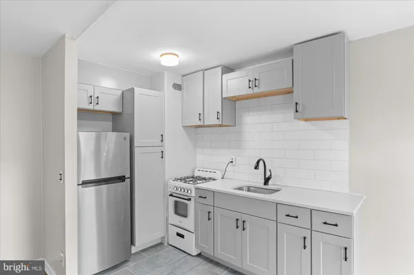 a view of a kitchen with a sink and refrigerator
