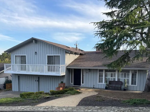 a front view of a house with yard and parking space