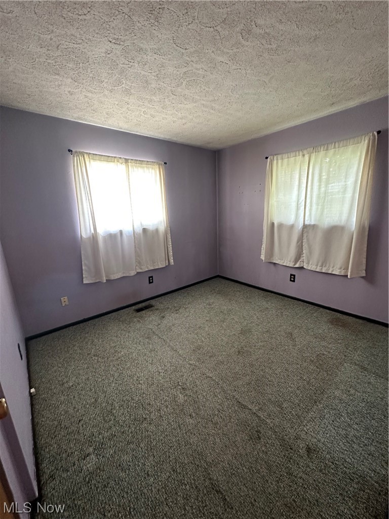 Carpeted bedroom with a textured ceiling