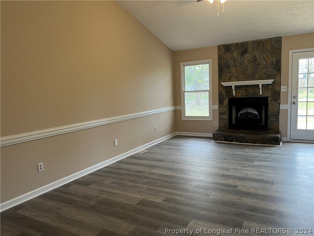 308 Kernstown Road Raeford, NC 28376 - Photo 2 of 15 a view of an empty room with wooden floor fireplace and a window
