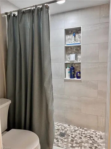 a bathroom with a toilet and a shower