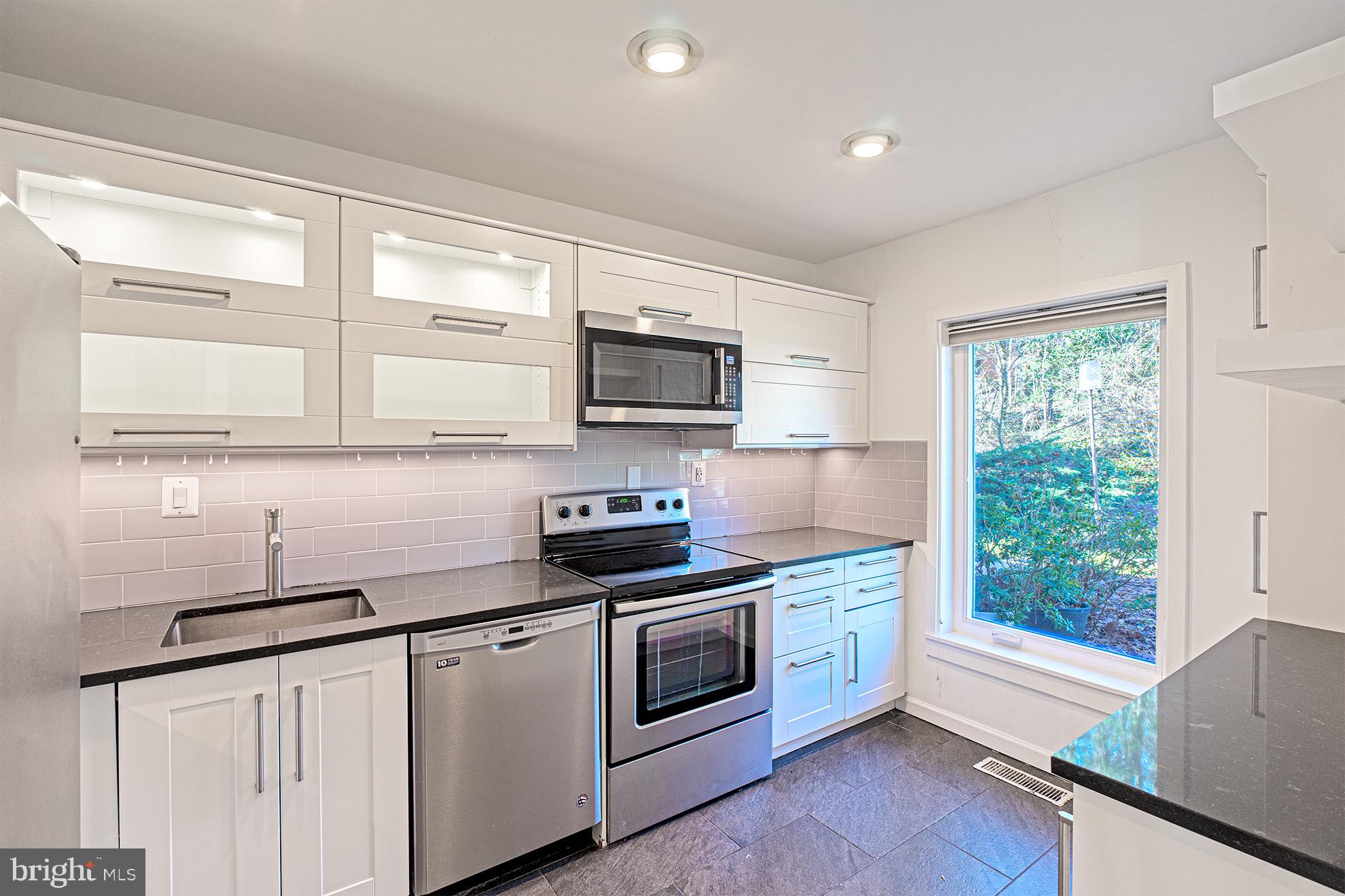 11495 Waterview Cluster Reston, VA 20190 - Photo 12 of 38 a kitchen with stainless steel appliances white cabinets a sink and a stove