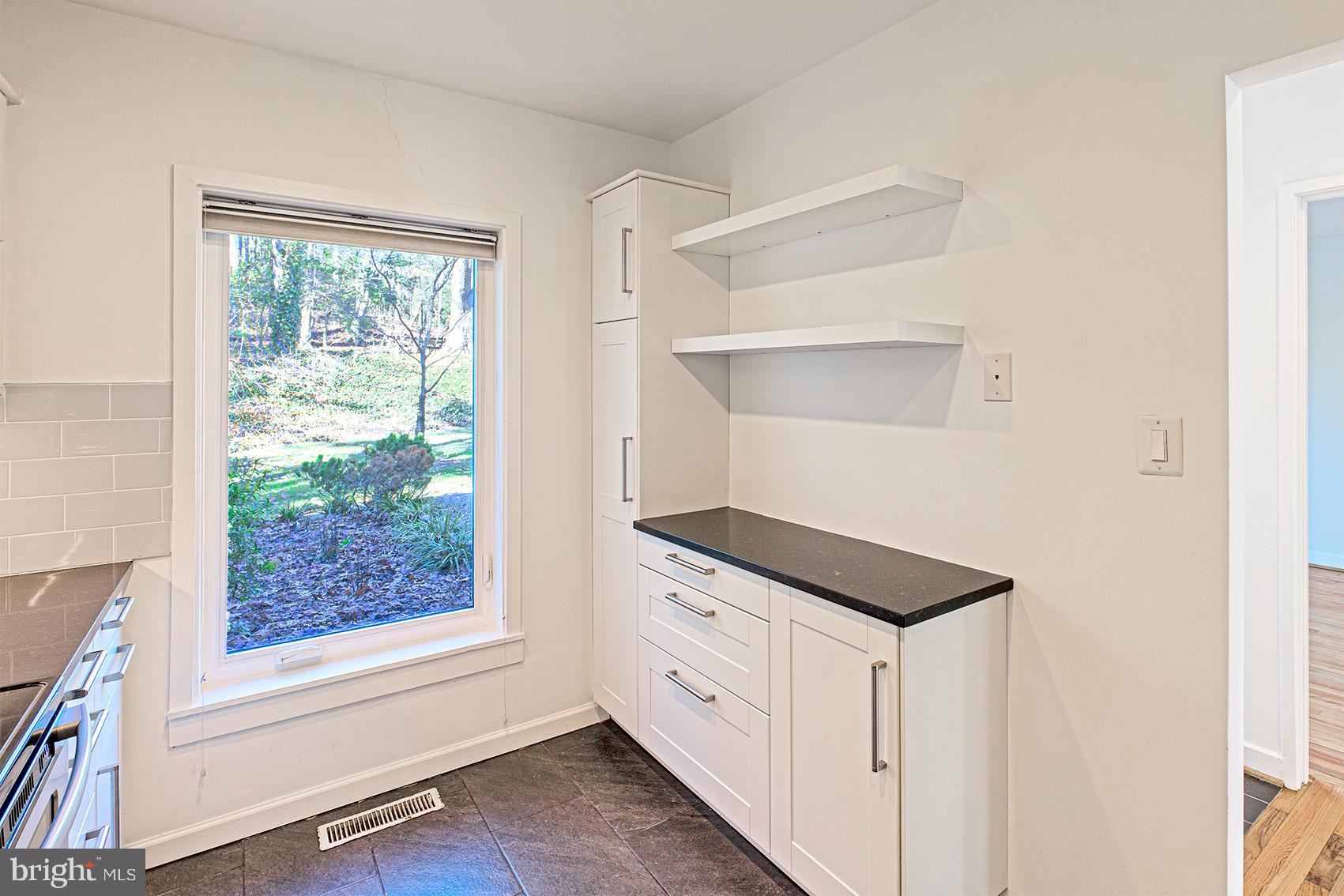 11495 Waterview Cluster Reston, VA 20190 - Photo 14 of 38 a kitchen with white cabinets and window