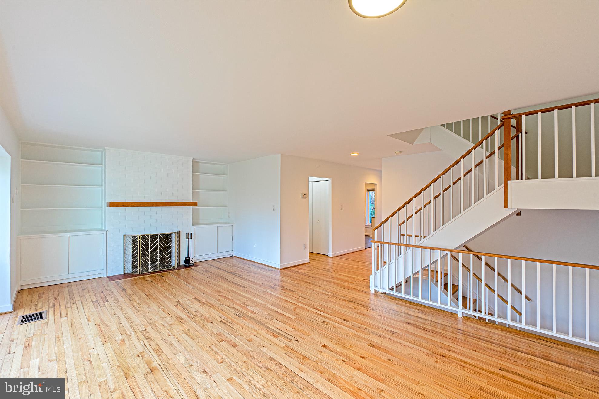 11495 Waterview Cluster Reston, VA 20190 - Photo 7 of 38 a view of a livingroom with wooden floor staircase and a kitchen