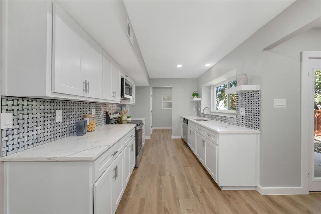 4213 Huckleberry Drive Fort Worth, TX 76137 - Photo 15 of 39 a kitchen with granite countertop white cabinets and white appliances