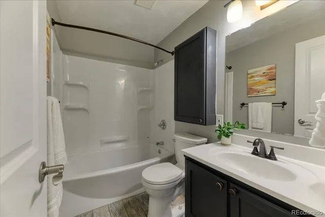 a bathroom with a granite countertop sink toilet and shower