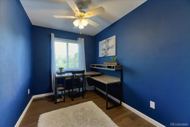 a view of a workspace with furniture and a window