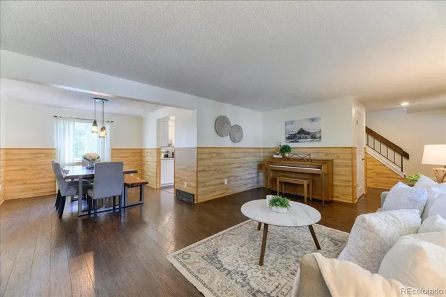 a living room with furniture and a wooden floor