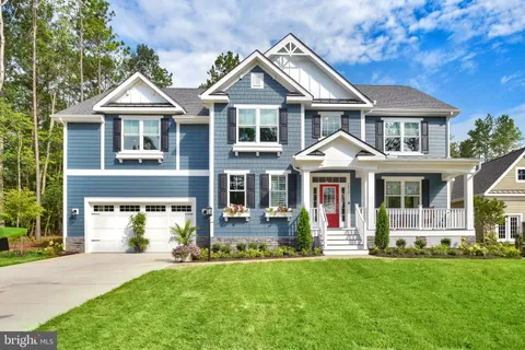 a front view of a residential houses with yard and green space