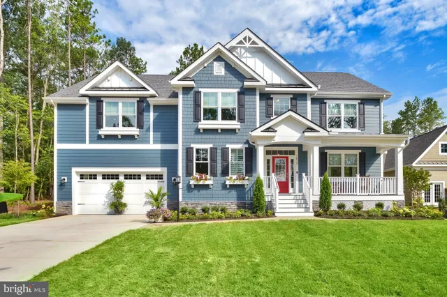 a front view of a residential houses with yard and green space