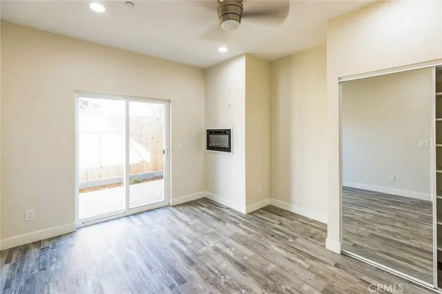an empty room with wooden floor and windows