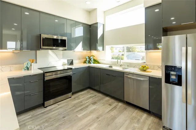 a kitchen with stainless steel appliances a sink stove and refrigerator
