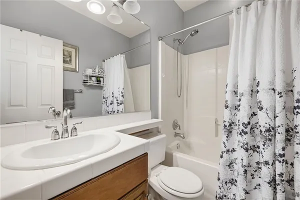 a spacious bathroom with a tub a sink and a mirror