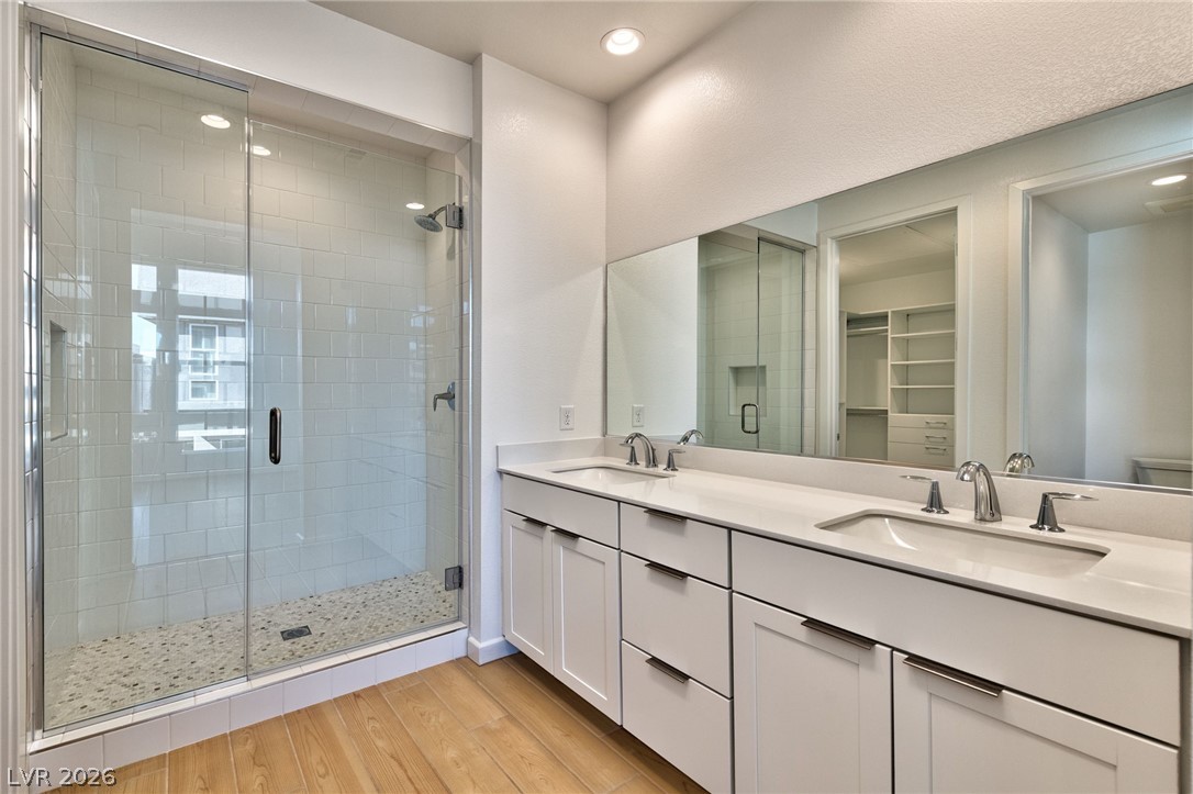 3327 Esker Rdg Avenue Henderson, NV 89044 - Photo 14 of 24 A well-lit primary bathroom featuring a spacious walk-in shower and dual vanity.