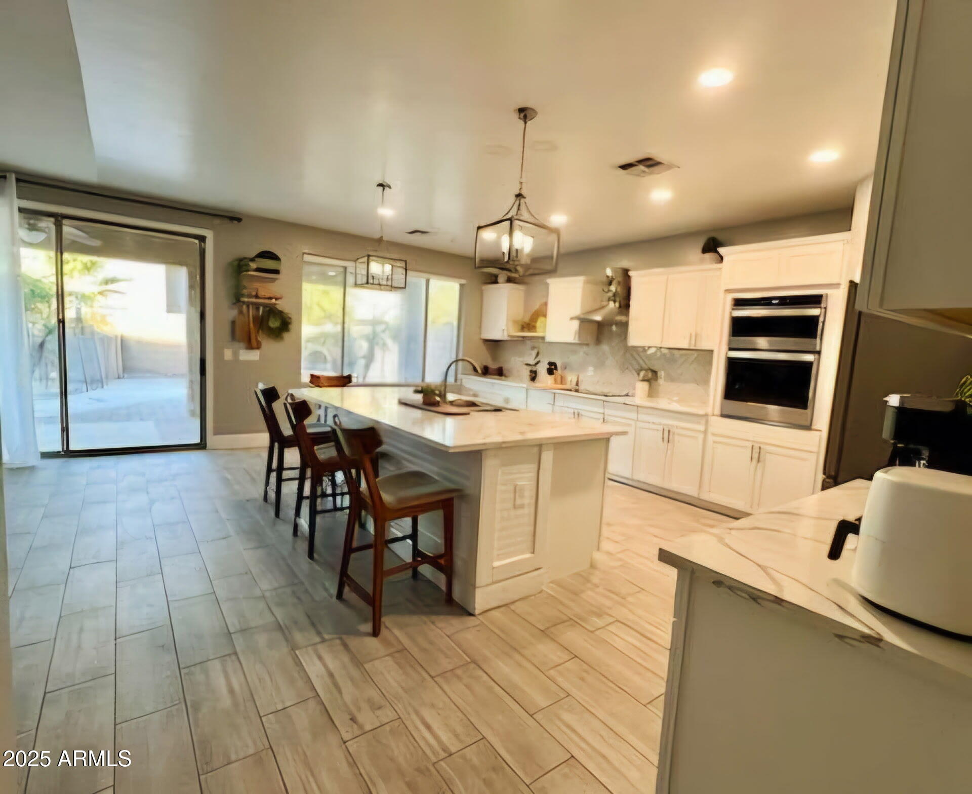 43578 West Cydnee Drive Maricopa, AZ 85138 - Photo 6 of 18 a kitchen with stainless steel appliances kitchen island granite countertop a sink cabinets and wooden floor
