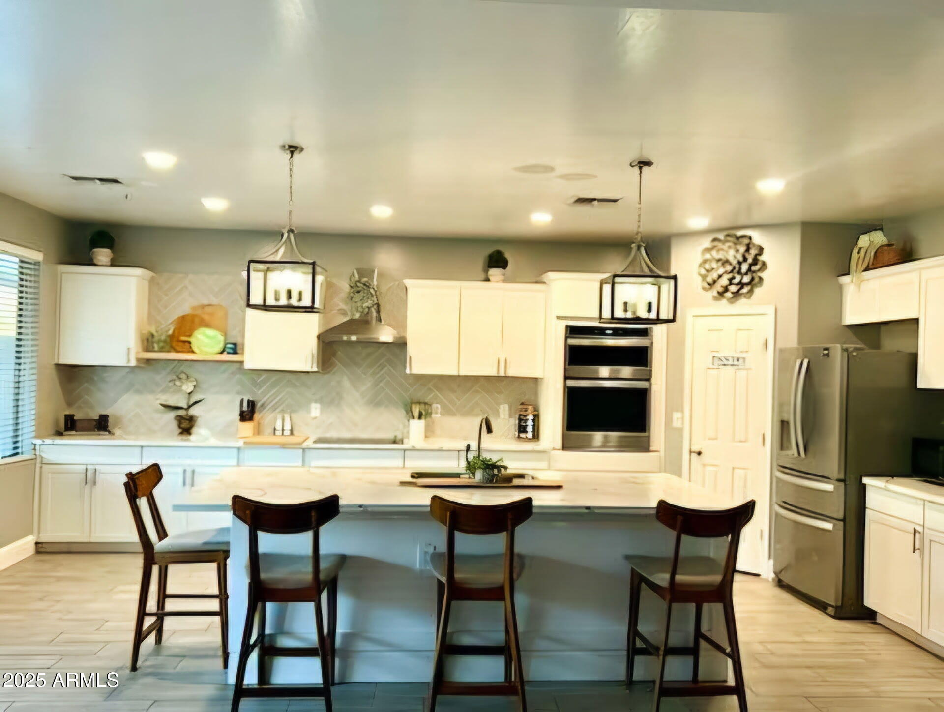 43578 West Cydnee Drive Maricopa, AZ 85138 - Photo 7 of 18 a kitchen with stainless steel appliances kitchen island granite countertop a dining table chairs refrigerator and sink