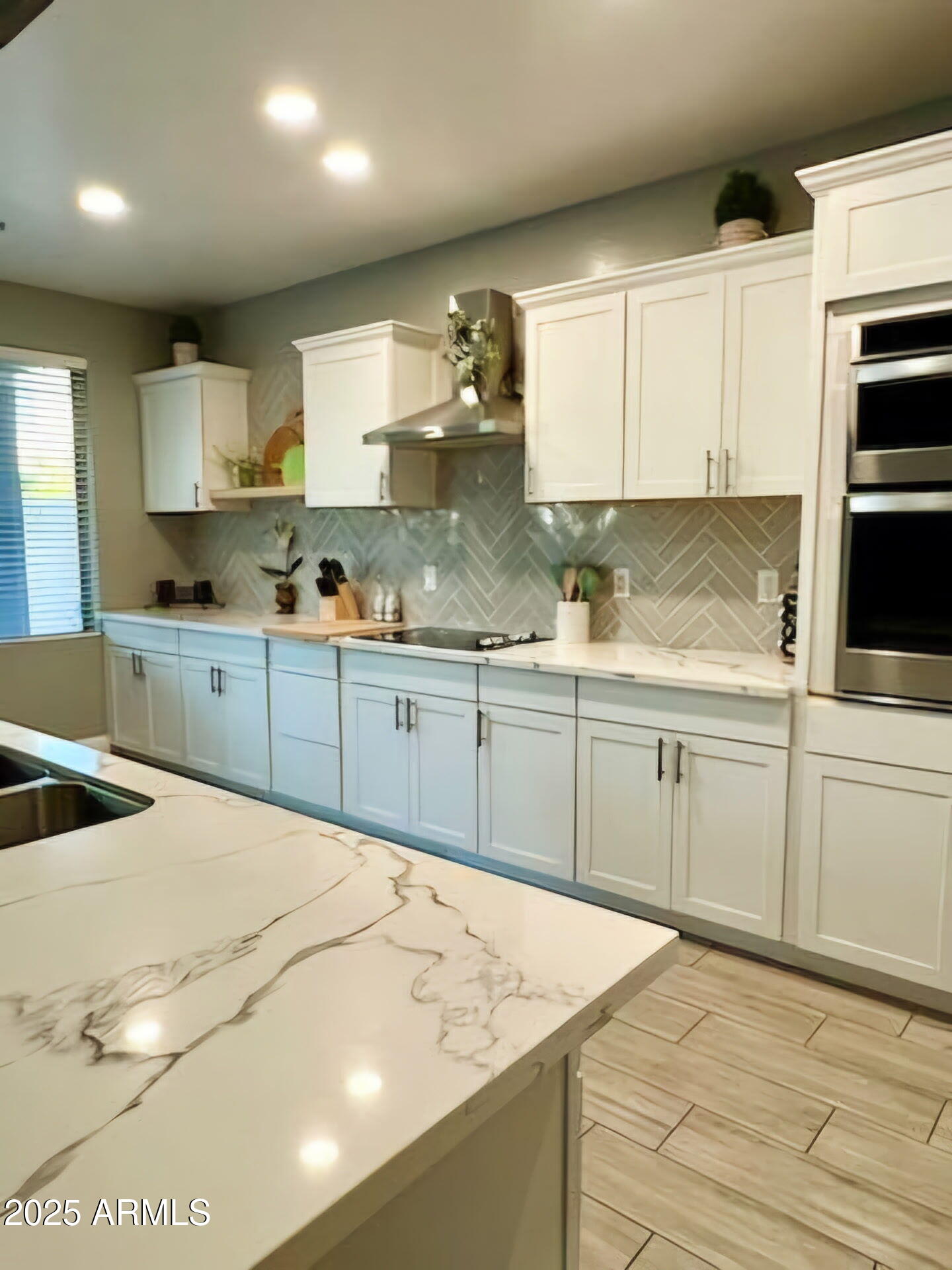 43578 West Cydnee Drive Maricopa, AZ 85138 - Photo 10 of 18 a kitchen with stainless steel appliances granite countertop a sink dishwasher a stove and white cabinets with wooden floor