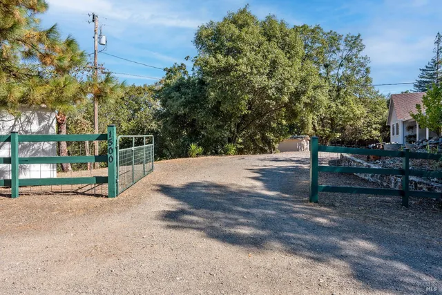 a view of a yard with wooden fence