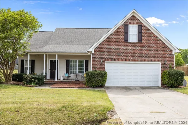 a front view of a house with a yard and potted plants
