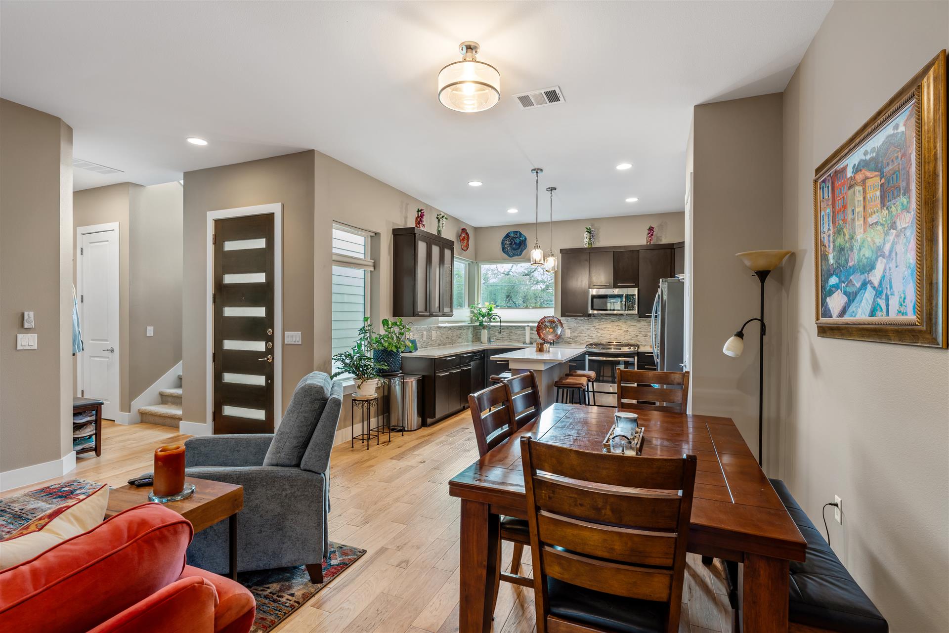 An open-concept layout seamlessly connects the dining area to the kitchen, creating a cohesive space accented by beautiful wood flooring.