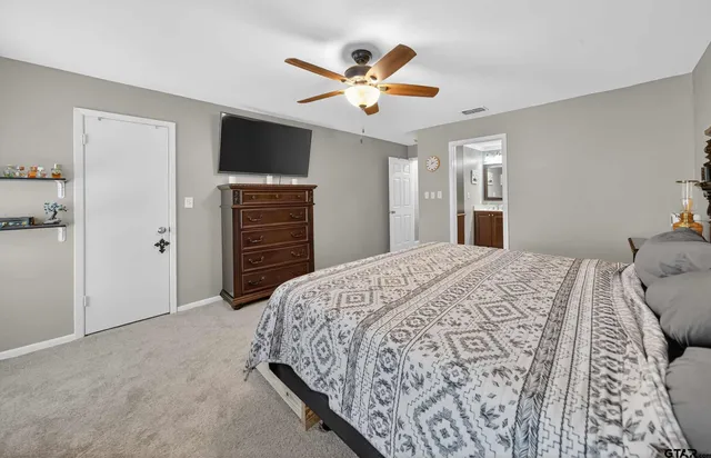 a bedroom with a large bed and a ceiling fan