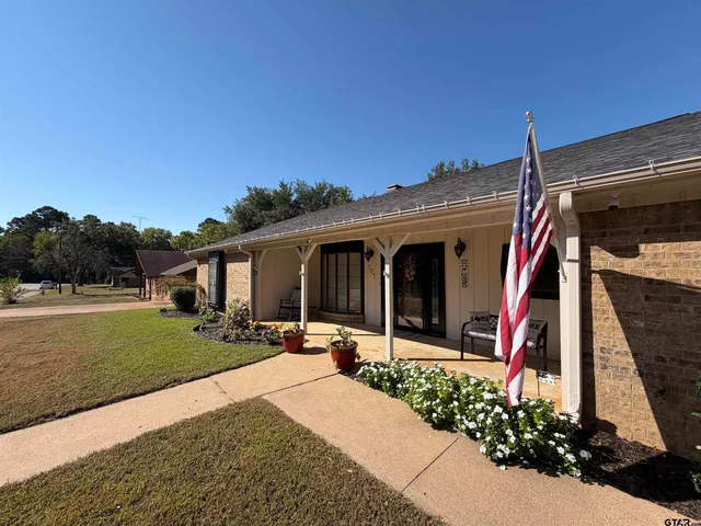 a front view of a house with porch and garden