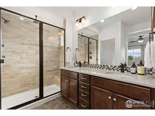a bathroom with a double vanity sink mirror and shower