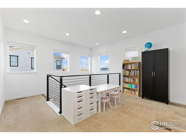 a living room with furniture a rug and white walls