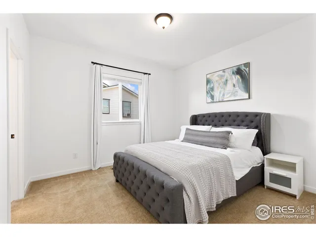 a bedroom with a bed and a painting on the wall