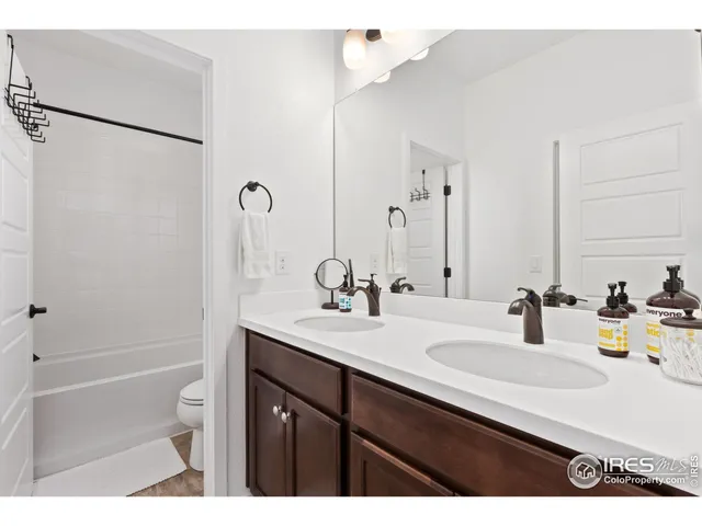 a bathroom with a sink double vanity granite tub shower and a mirror