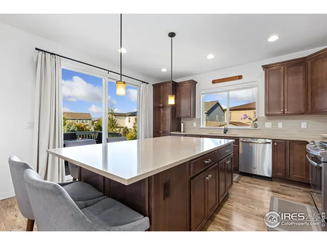 a kitchen with kitchen island granite countertop a sink and a refrigerator