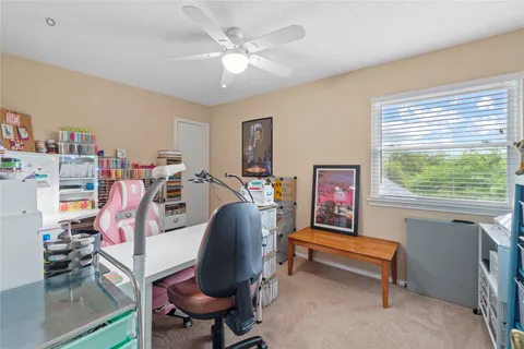 a view of a workspace with furniture and a window