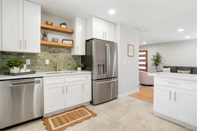 a kitchen with white cabinets and stainless steel appliances